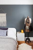 Dark grey painted feature wall in modern bedroom 