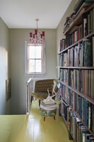 Bookcase on upstairs landing with yellow painted floor