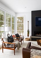 Wooden armchairs by large windows in modern living room 