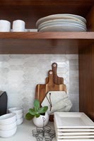 Crockery and cooking accessories on wooden shelving unit 