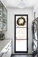 Christmas wreath on black framed glass door in modern kitchen 