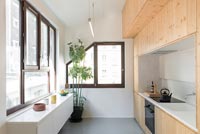 Compact kitchen built-in to wooden feature wall 