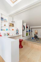 Modern childrens room with built-in shelving and open wardrobe 