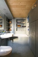 Modern concrete bathroom with wooden ceiling 