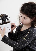 Child drawing on plant pots
