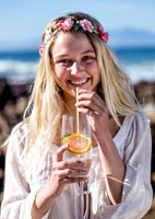 Young woman drinking a drink at the beach 