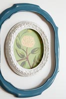 Close up of floral painting within two picture frames on wall 