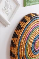Colourful stripy basket on wall as decoration 