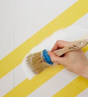 Painting white over yellow diagonal stripes on wall 