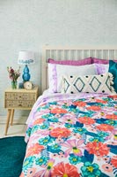 Vintage furniture and colourful bedding in bedroom 