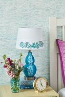 Floral patterned lampshade on bedside table 