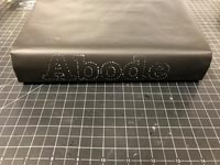Decorated book spine - the word abode in white spots on black book 
