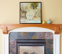 Fireplace with decorative tiles and painting on mantelpiece 