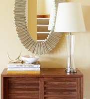 Wooden slatted cabinet, lamp and mirror in modern hallway 