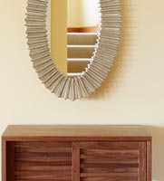 Wooden slatted cabinet and mirror in modern hallway 