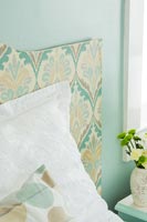Headboard covered in patterned wallpaper 