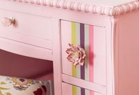 Pink flowers door knobs on colourful painted dressing table 