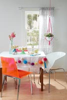Modern dining room with decorative macrame and pom poms 