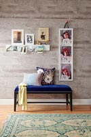 Decorative frame of photographs on wall by divan seat