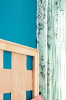 Wooden headboard against blue painted wall
