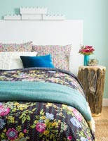 Large white headboard and floral bedding in modern bedroom 