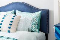 Blue velvet headboard and variety of pillows 