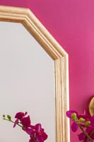 Detail of mirror on pink painted wall 