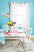 Turquoise and white dining room with painted chairs 