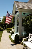 American flag on pole on porch of country house 