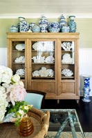 Wooden vitrine cabinet filled with ceramics 