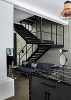 Modern open plan living space with metal staircase 