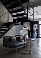 Modern living room with metal staircase and concrete floor