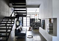 Modern living room with metal staircase and concrete floor