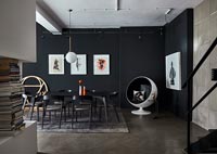 Modern dining room with black painted wall and concrete floor 
