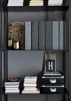 Black and grey items on bookshelf 