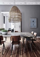 Wooden dining table in modern dining room with grey painted walls 