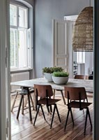 Wooden dining table in modern dining room with grey painted walls 