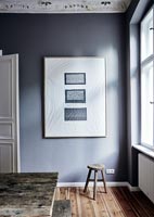 Framed white artwork on grey painted wall in dining room 