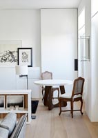 Small table and chairs in corner of living room by French windows 
