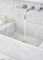 Chrome mixer taps in marble sink - running water 