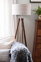 Wooden tripod floor lamp in country living room 