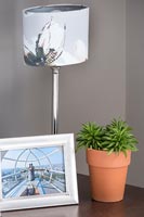 Bedside table with lamp, wedding photograph and plant 
