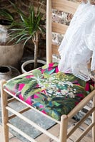 Colourful fabric on wooden chair seat 