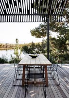 Modern outdoor dining area overlooking lake 