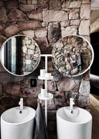 Modern bathroom with exposed stone wall - double sinks 