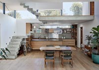 Contemporary open plan living space with concrete stairs and mezzanine landing