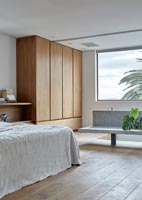 Contemporary wooden bedroom with concrete bench 