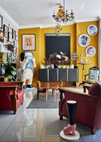 Eclectic living room with yellow painted feature wall 