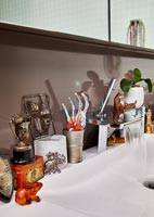 Eclectic ornaments on bathroom sink unit 