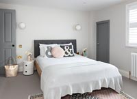 Modern monochrome bedroom with pastel accessories 